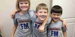 Kids hanging out and wearing freeway music shirts before their guitar lessons.
